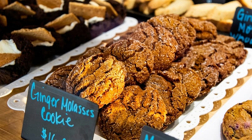 Close-up of ginger molasses cookies on a white tray, with a small sign in front.